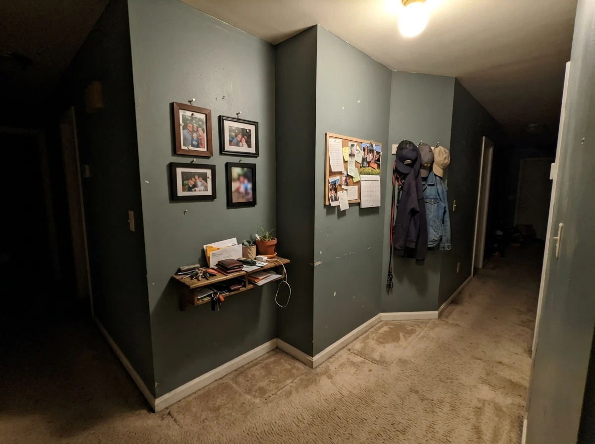 Windowless hallway showing Behr Hidden Gem appearing muddy and gray under poor lighting.