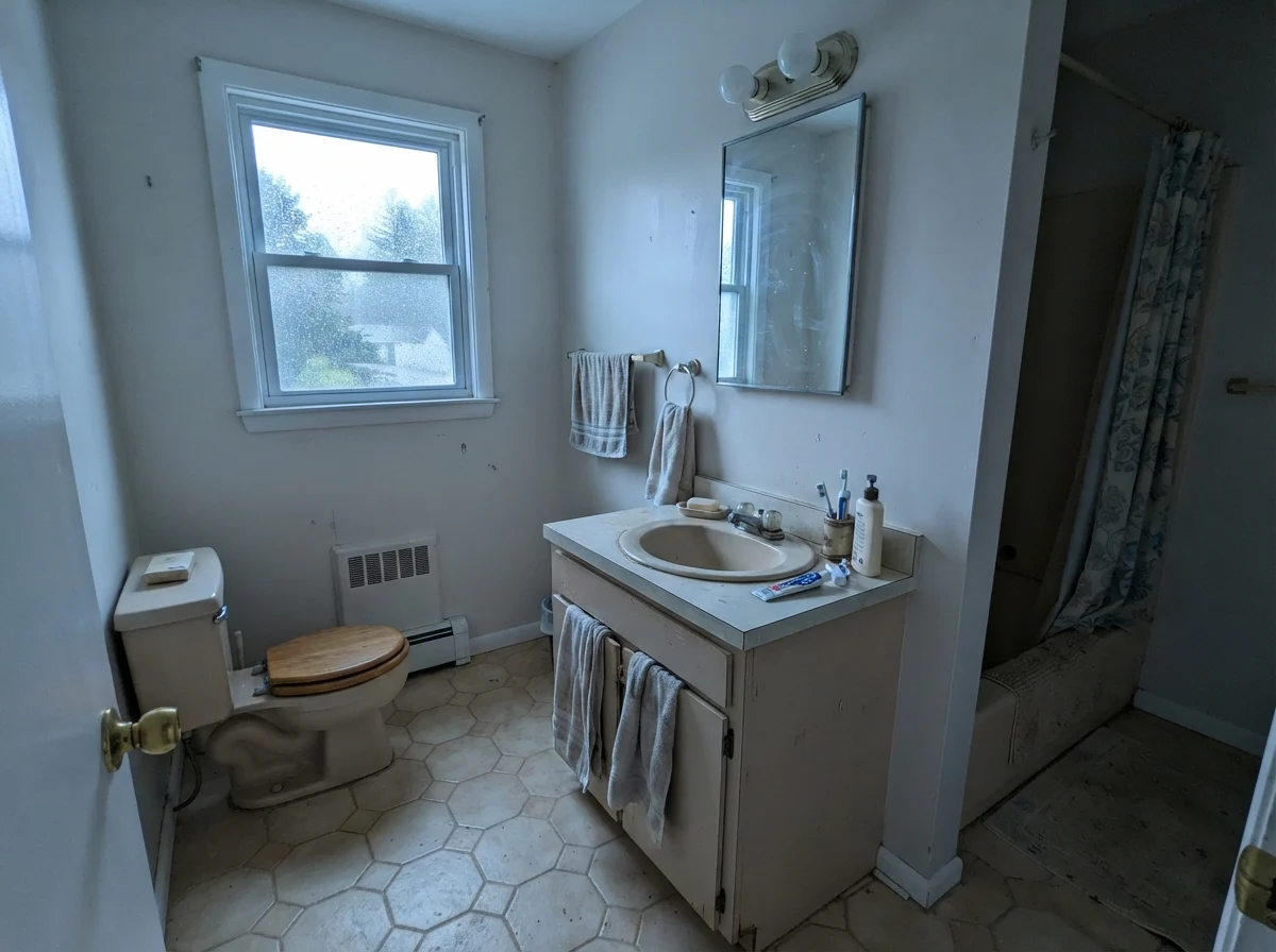 Modest bathroom showing cooler cast on painted walls with older beige vanity