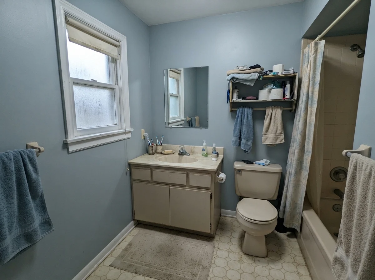Dated bathroom showing painted walls with a cool cast beside an older beige vanity