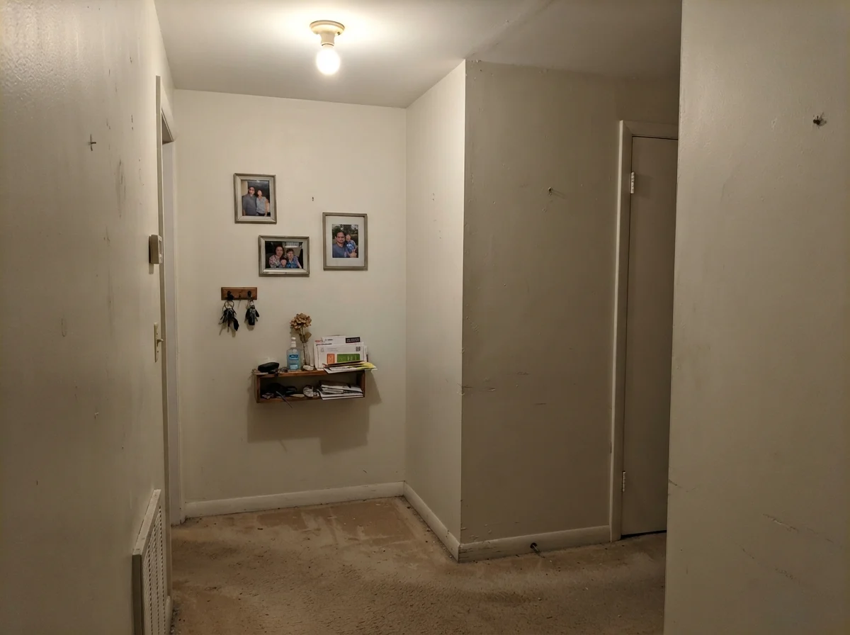 Windowless hallway corner showing Simply White looking flat and dull under a single incandescent fixture.