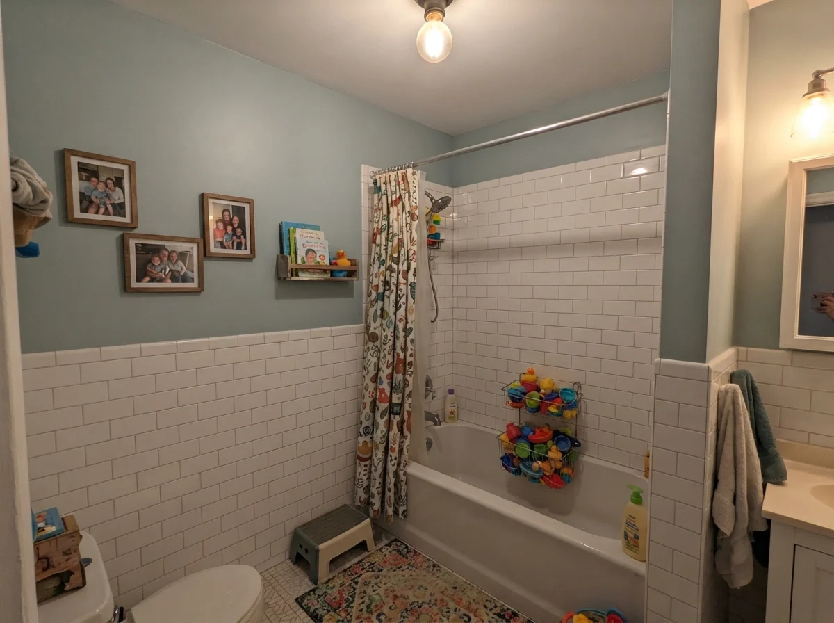 Kids bathroom with painted walls over white subway tile and bath toys