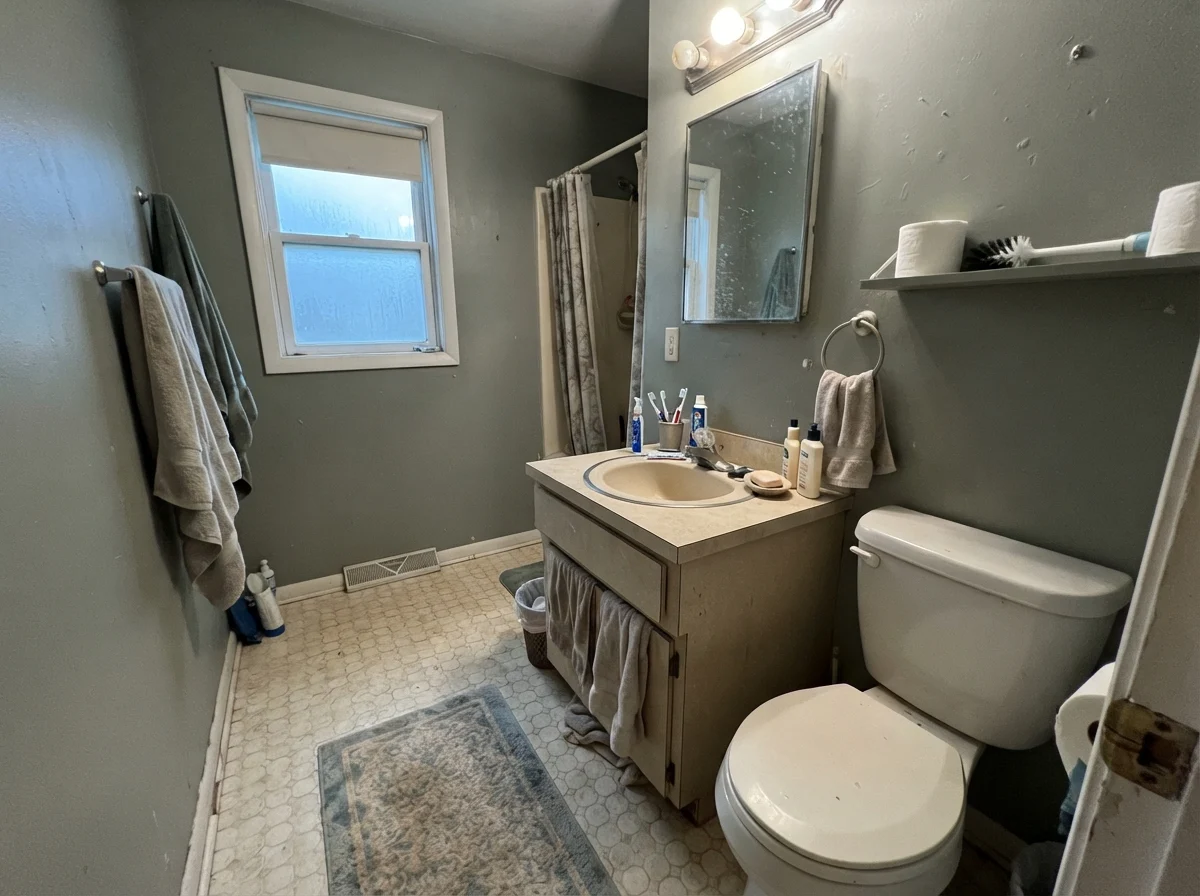 Dated bathroom on a rainy day showing paint looking cool and muted against an older beige vanity.