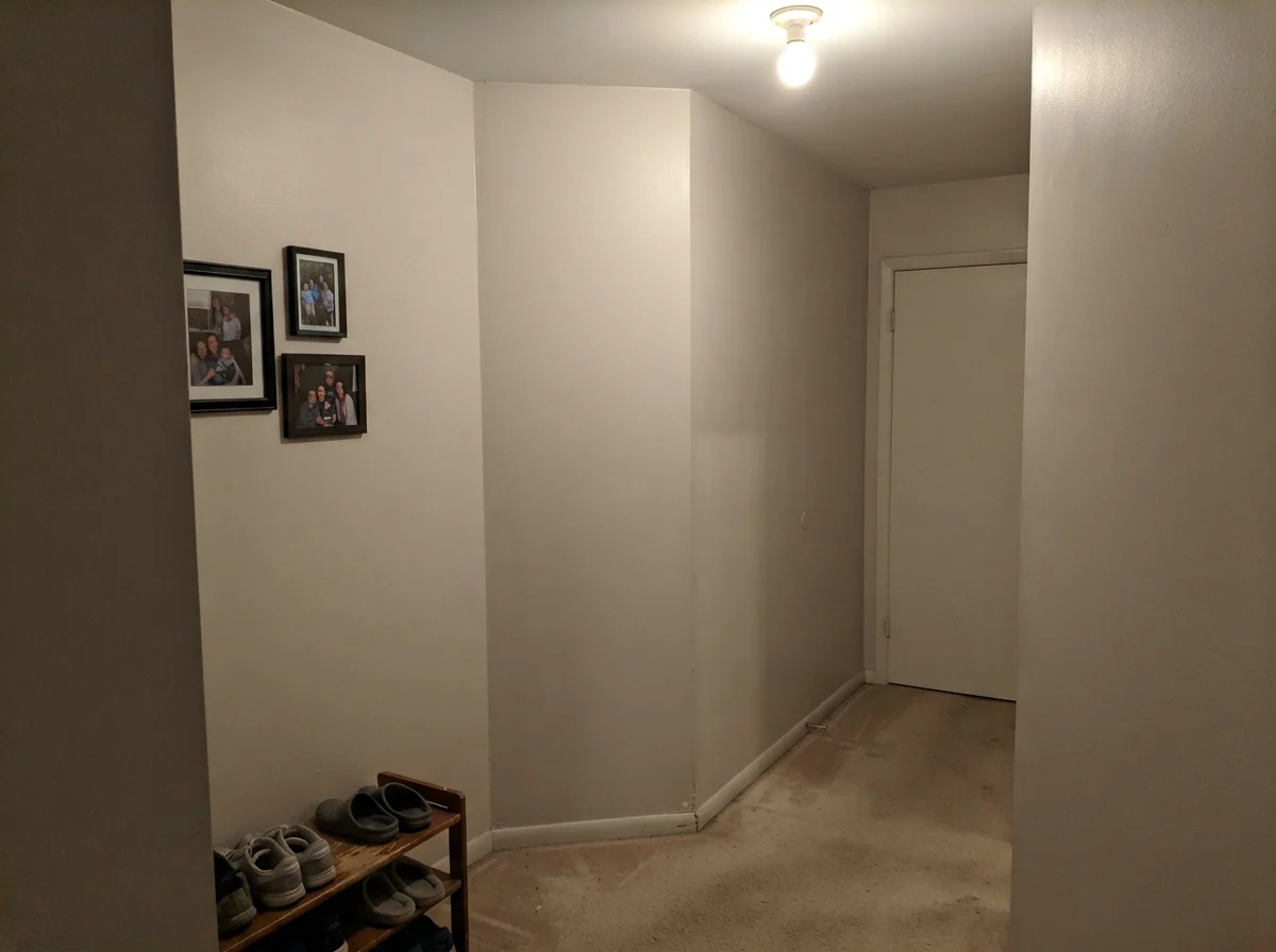 Windowless hallway corner showing Natural Choice looking flat and muddy under single ceiling bulb