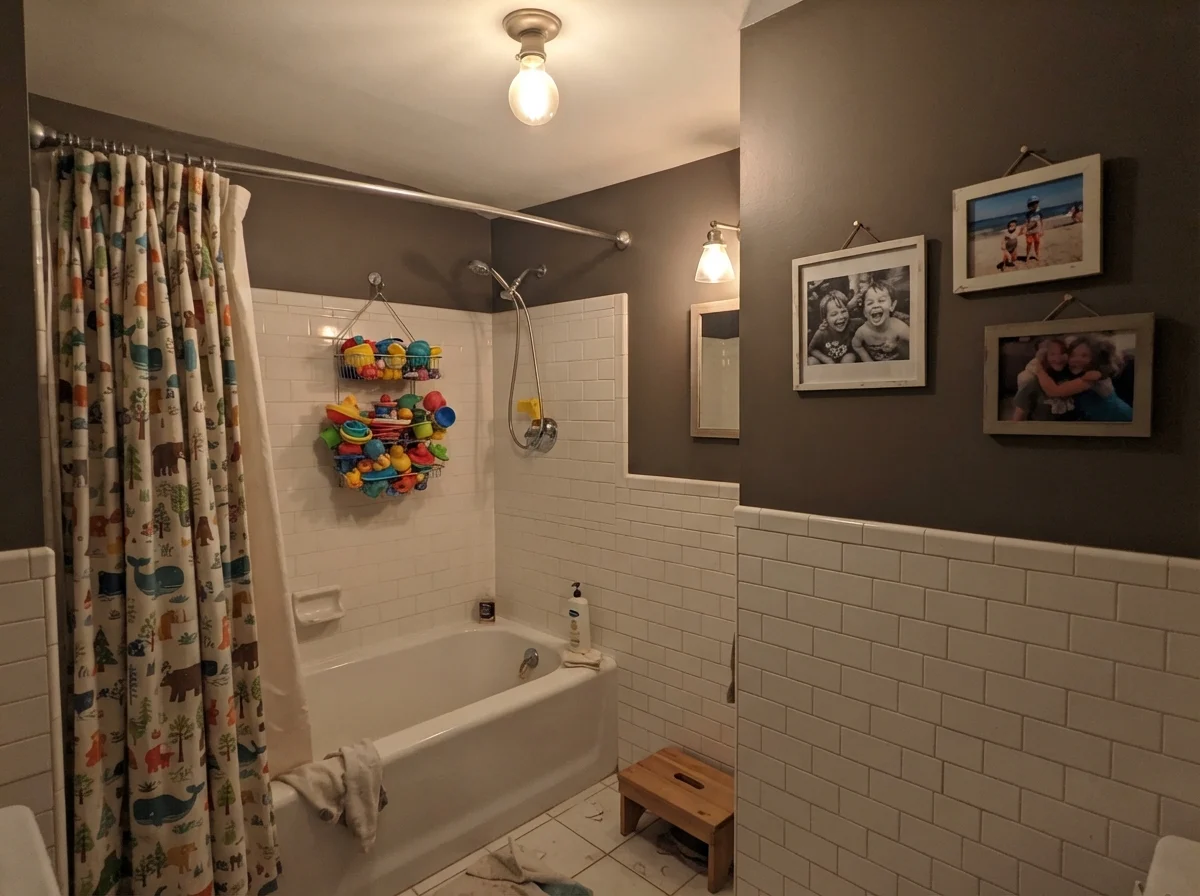 Kids bathroom with bath toys and Porpoise walls over white subway tile
