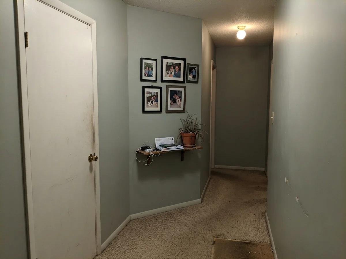 Dim hallway corner showing Tradewind painted wall reading flat and muddy under single ceiling bulb